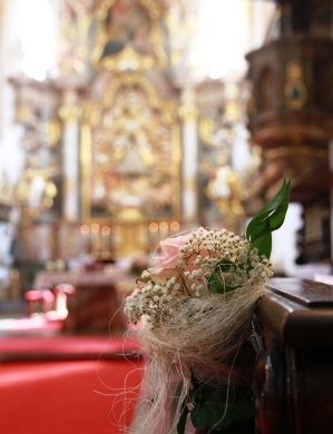 Die KirchenbÃ¤nke in der Wallfahrtskirche Maria Himmelfahrt in Sossau, geschmÃ¼ckt mit Rosen und Schleierkraut.