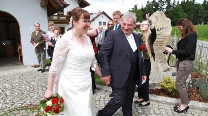Das glÃ¼ckliche Brautpaar Monika und Horst-Peter werden nach der Segnung von den GÃ¤sten mit weiÃŸen Papier-Herzen Ã¼berhÃ¤uft.