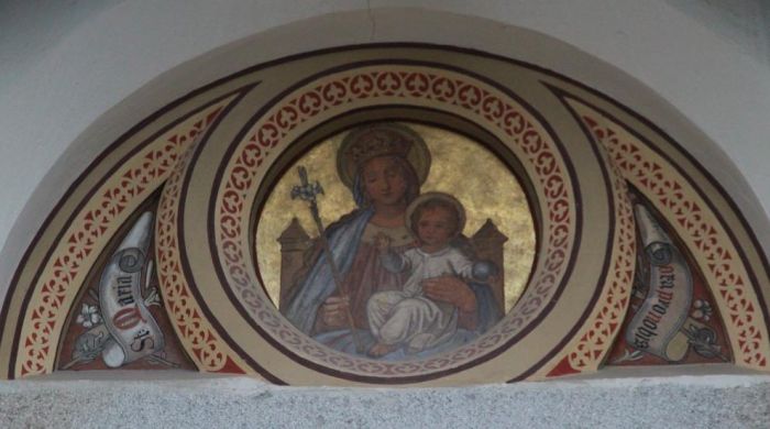 Ãœber dem Eingang begrÃ¼ÃŸt uns die Heilige Maria mit dem Jesuskind. Daneben sind die Worte "St. Maria ora pro nobis"(Heilige Maria, bitte fÃ¼r uns) zu lesen.