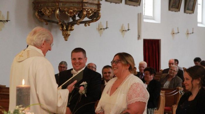 Pfarrer Michael Killermann sowie die GÃ¤ste freuen sich mit dem Brautpaar Lena und Maximilian. Bald ist es soweit: sie geben sich das Ja-Wort.