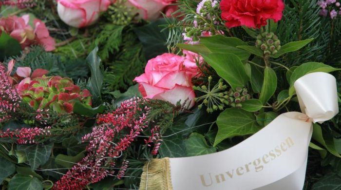 Der wunderschöne Blumenschmuck am Grab erinnert an zwei liebe Menschen.
