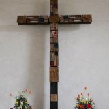 Das Wandkreuz aus Bronzeguss und Emailteilen von Professor Hermann JÃ¼nger (* 1928 in Hanau; â€  2005 in PÃ¶ring bei MÃ¼nchen) trÃ¤gt die Namen der vier Evangelisten an den Enden. Gefertigt in der GieÃŸerei Rickl in Burglengenfeld.