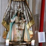 Auf der linken Seite die Darstellung der Hl. Maria mit dem Jesuskind. Rechts daneben sieht man ein StÃ¼ck der roten "Holzkirchener Pfingstkerze".