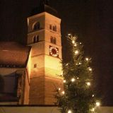 Die Wallfahrtskirche MariÃ¤ Himmelfahrt auf dem Bogenberg erstrahlt im Glanz des beleuchteten Weihnachtsbaumes im Vordergrund.