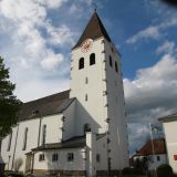 Die Pfarrkirche St. Nikolaus in Hunderdorf bei weiß-blauem Himmel.