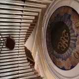 Über der Orgel befindet sich ein eindrucksvolles Rund-"Fenster" mit dem Marienmonogramm.